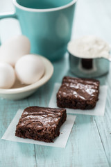 Close up of Brownies With Eggs and Flour and a Coffee Cup