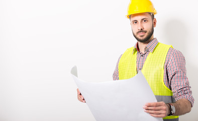 Construction worker posing with blueprints studio shot