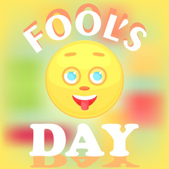 Festive card for the day of the fool. The face of the smiley icon shows the tongue, the cheerful is isolated on a blurry background, the text with a shadow.