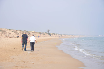 Fototapeta na wymiar People strolling by the sea on a sunny day