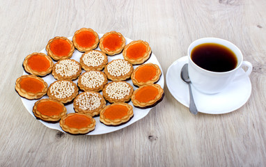 A cup of coffee and assorted cookies on the table.