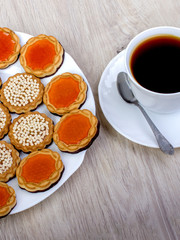 A cup of coffee and assorted cookies on the table.