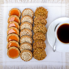 A cup of coffee and assorted cookies on the table.