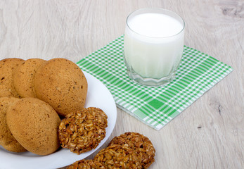 A glass of milk and assorted cookies on the table.