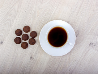 Dessert candies and a cup of coffee on a wooden table
