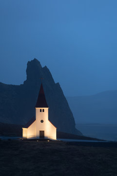 Vik i Myrdal Church in Iceland with mountain in the background taken at dusk.
