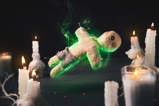 Voodoo doll with dramatic lighting on a wooden background