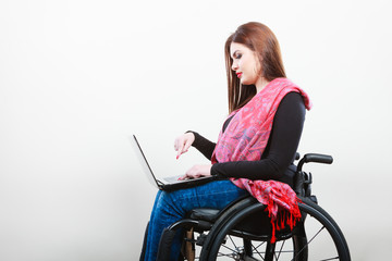 Young girl on wheelchair surfing web.