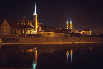 Fototapeta na wymiar Cathedral Island or Ostrow Tumski with Cathedral of St. John and church of the Holy Cross and St. Bartholomew at night in Wroclaw, Poland