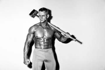 athlete and hammer. guy with a nice muscle fitness, bodybuilder hold big metal hammer