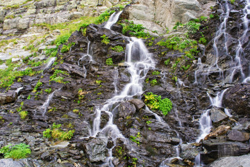 Waterfall on mountain river in Carpathian Mountains , Romania