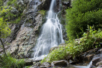 Obraz premium Waterfall on mountain river in Carpathian Mountains , Romania