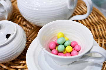 .Colorful sweet jelly beans in porcelain mug on table