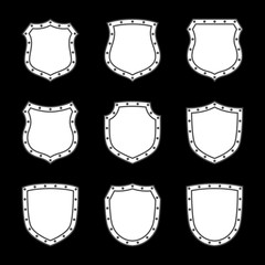 Shield shape icons set. White label signs isolated on black background. Symbol of protection, arms, security, safety. Flat retro style design. Element vintage heraldic emblem Vector illustration