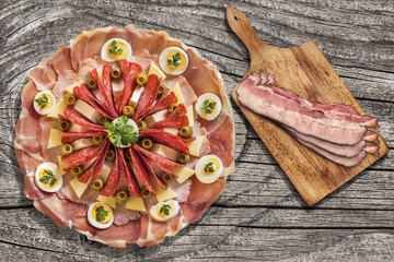 Appetizer Savory Dish Meze with Bacon Rashers Set on Old Knotted Cracked Wooden Garden Table