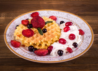 Waffle with fruit on a wooden background. Breakfast concept