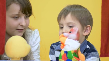 Little girl and cute boy playing with hand toys in puppet show
