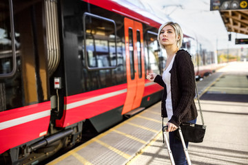 Woman With Luggage Standing At Train Station