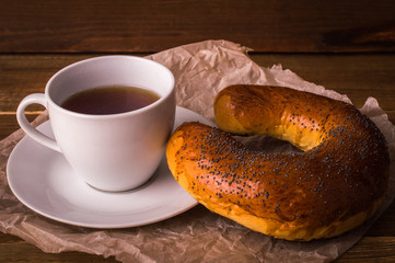 Poppy bun and coffee on a wooden background