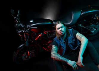 Fototapeta na wymiar biker caucasian man sitting near motorcycle motorbike