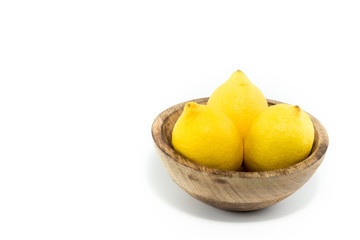 Lemons - limão siciliano - in a natural handmade real wood bowl isolated in black background