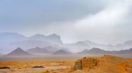 Foto op Plexiglas desert area in the central part of Iran, on a background towers a mountain chain, in the sky rain clouds © Tortuga