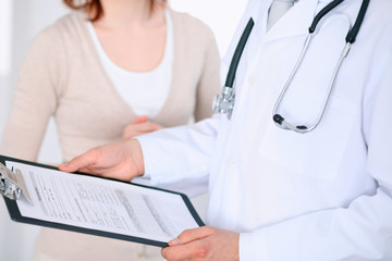 Close up of a male doctor holding an application form while consulting patient