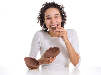 Obraz premium Young girl smiles and looks like chocolate bonbon. Easter egg next to you.