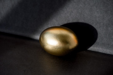 Obraz premium The Golden egg , a symbol of wealth and investment, rests on the foil. Brilliant picture