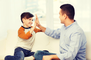 happy father and son doing high five at home