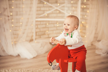 lovely little baby boy riding rocking deer. © nata_zhekova