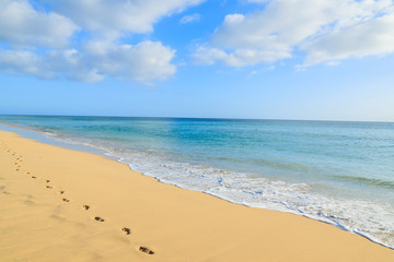 Fototapeta na wymiar Footprints in golden sand beach on Jandia peninsula, Morro Jable, Fuerteventura, Canary Islands, Spain