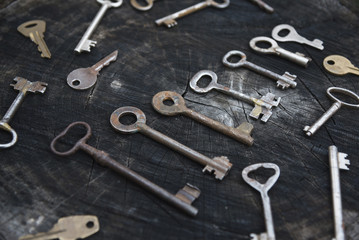 Scattered collection of old keys on a wooden surface