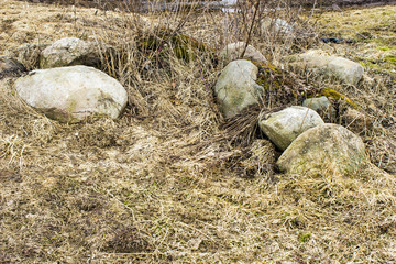 Fototapeta na wymiar Large stones on dry grass in the field