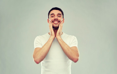 happy young man applying aftershave to face