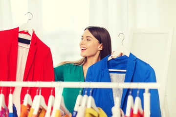 happy woman choosing clothes at home wardrobe