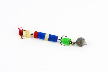 Exhibition of self-made fishing metal lures. Bait for fishing in the shape of a spoon with a hook on a white background.