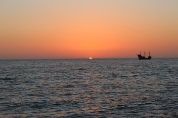 Fototapeta na wymiar pirates on the gulf at sunset