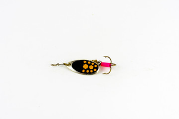 Exhibition of pirated copies of fishing metal spoon baits. Bait for fishing in the shape of a spoon with a hook on a white background