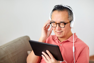 man with tablet pc and headphones at home