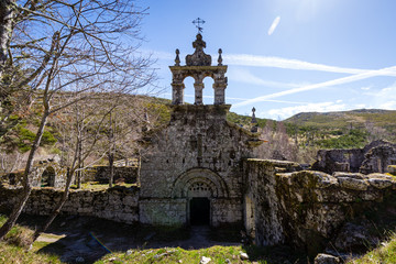 Ruines and Church of the monastery "Mosteiro de Santa Maria das Júnias" against blue sky, Portugal