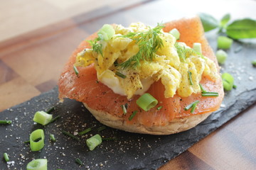 Open sandwich with salmon, scrambled egg, chive, dill, spring onions, salt and pepper
