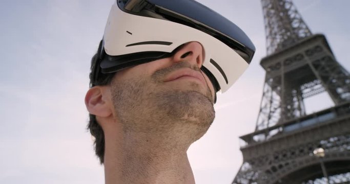 Tourist Man wearing virtual reality headset looking at Eiffel Tower Paris watching 360 video imagination concept