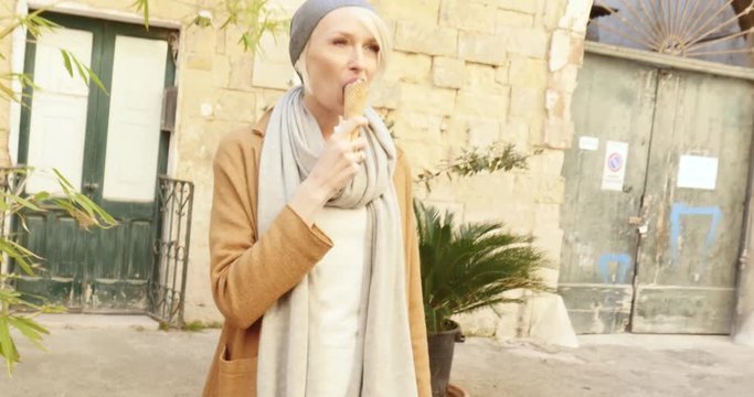 Beautiful young caucasian woman eating ice cream, smiling, relaxing. Italy.