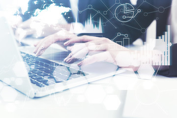 Close up of a woman typing at laptop, graphs