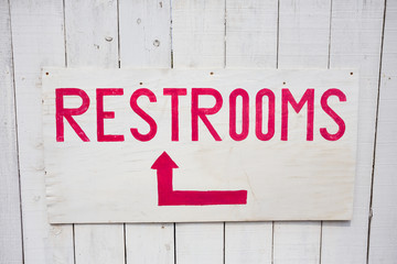 Red and White Restrooms Sign with Arrow