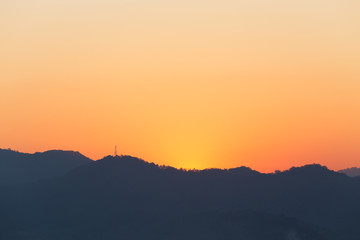 Silhouetted Telegraph Tower and Mountain Range at Sunset