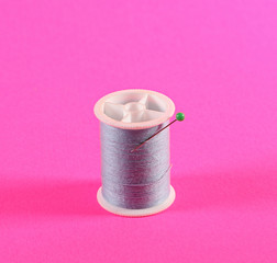 Fototapeta na wymiar Light blue thread in a pink background