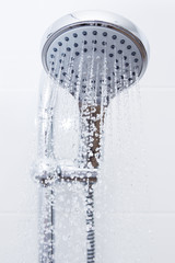 Obraz na płótnie Canvas Image of a modern shower head splashing water close up background.