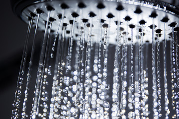 Fototapeta na wymiar Image of a modern shower head splashing water close up background.